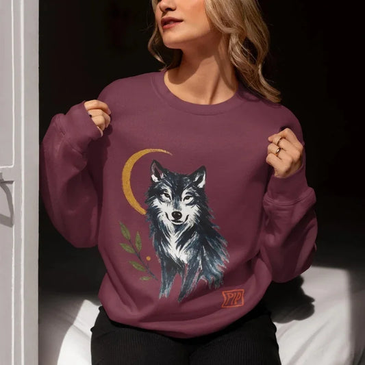 Woman wearing purple sweatshirt with mystical wolf, crescent moon, and botanical print design