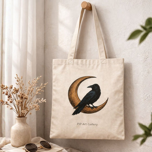 Canvas tote bag with raven and crescent moon artwork hanging on a wall hook.