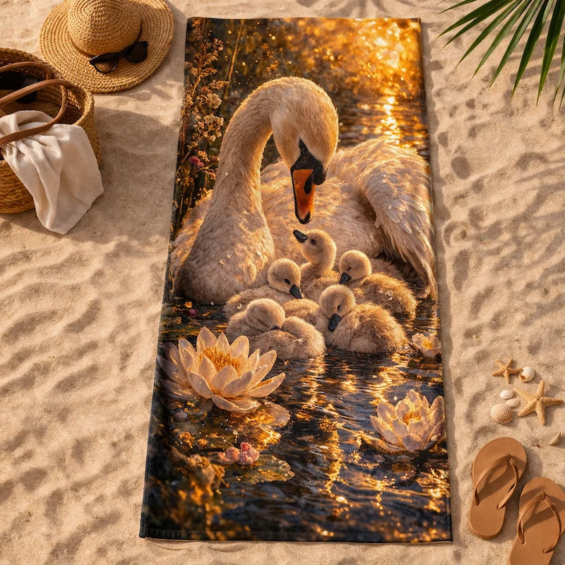 Beach towel with swan and cygnets art, surrounded by water lilies, on sandy beach scene