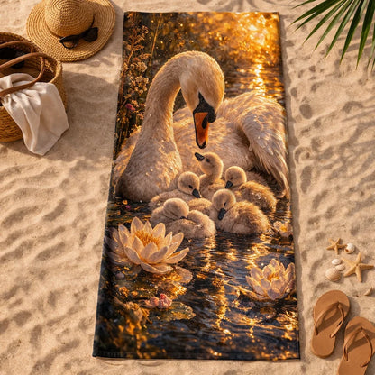 Beach towel with swan and cygnets art, surrounded by water lilies, on sandy beach scene